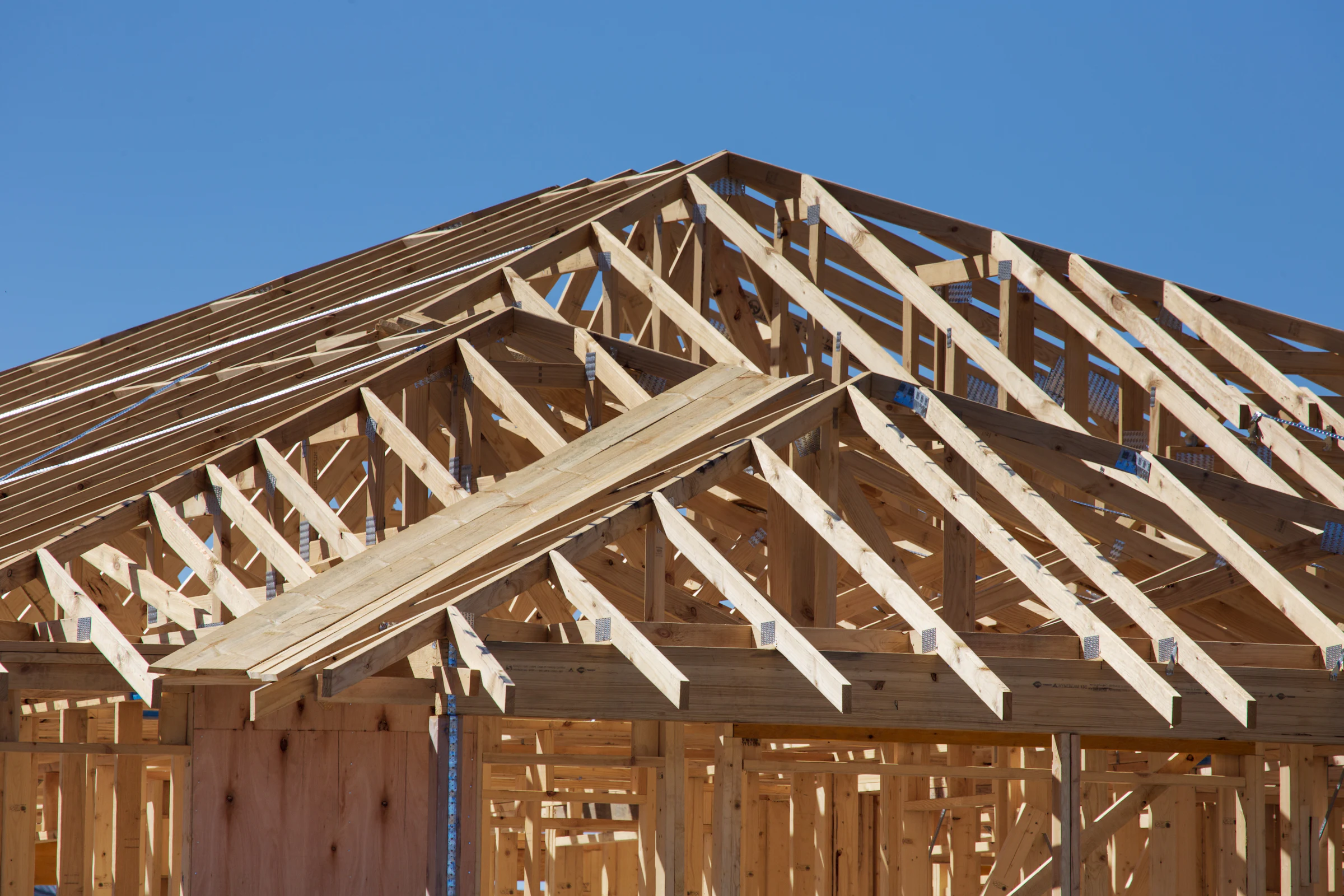 Haus im Bau mit frisch aufgestelltem Dachstuhl aus Holz